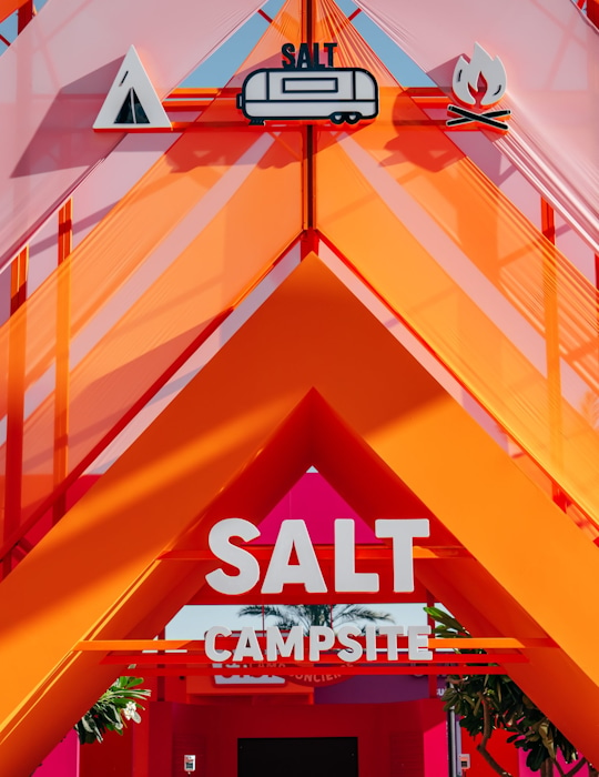 Studio Königshausen’s design for SALT CAMP in Dubai redefines camping for foodies, blending the charm of the great outdoors with a touch of glamour. We’ve created two dining areas, one for SALT and one for Sugar, offering savory meals and sumptuous desserts. The space is filled with interactive features, including a camping store, campfire confession table, and a stargazing area, all reflecting the brand’s personality. Königshausen: your partner in design, concept development, and scenography.